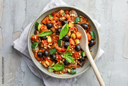 Photos ratatouille with onion tomatoes, celery, zucchini, black olives, celery, pine nu