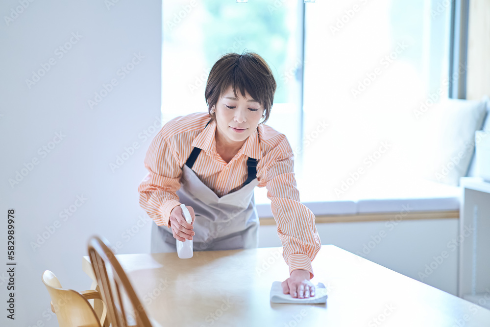 ダイニングテーブルを拭く女性 Stock Photo | Adobe Stock