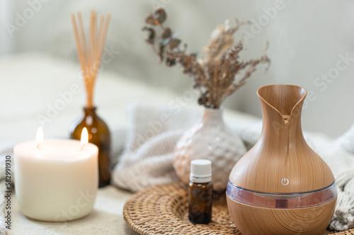 Spa composition with aroma oil diffuser lamp on a blurred background.