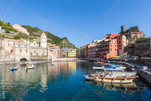 Italy, Liguria, Vernazza, Edge of coastal town along Cinque Terre with boats moored in foreground