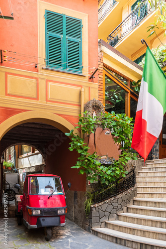 Italy, Liguria, Monterosso al Mare, Piaggio Ape riding through arched alley photo
