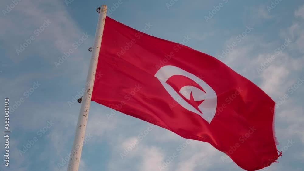 National flag Tunisia waving on wind on top protective fortress Ribat, Monastir. National symbols of an africam country.