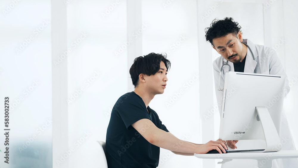パソコンを見ながら話す医療従事者 医師 看護師 パソコンを見ながら話す医療従事者 医師 看護師