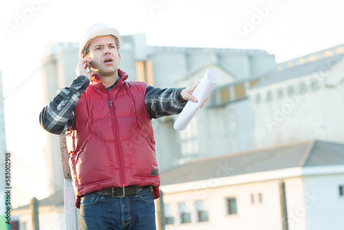 engineer man in helmet controlling outdoor construction site