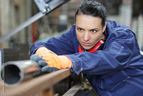young female industrial engineer taking measures of metal pipe © auremar