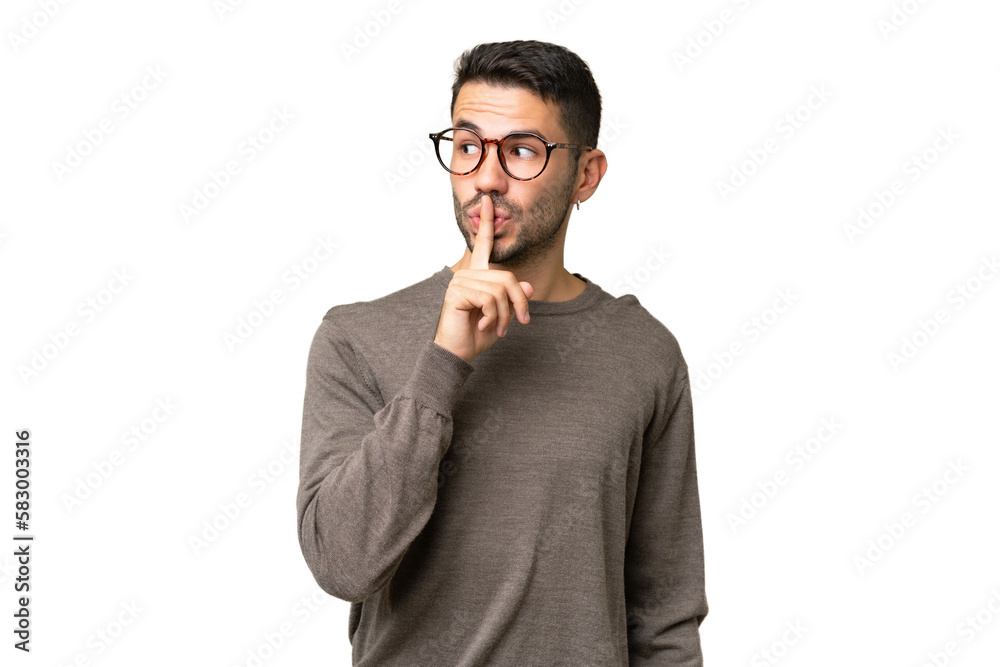 Young handsome caucasian man over isolated background showing a sign of silence gesture putting finger in mouth Young handsome caucasian man over isolated background showing a sign of silence gesture putting finger in mouth
