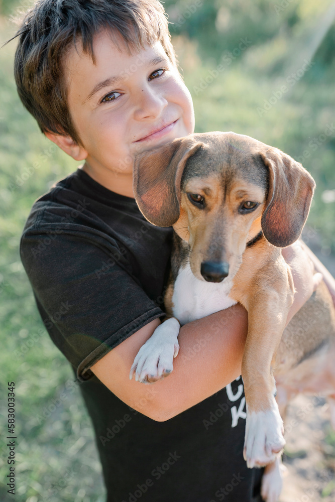 Cute smiling boy carrying brown outbred dog Cute smiling boy carrying brown outbred dog