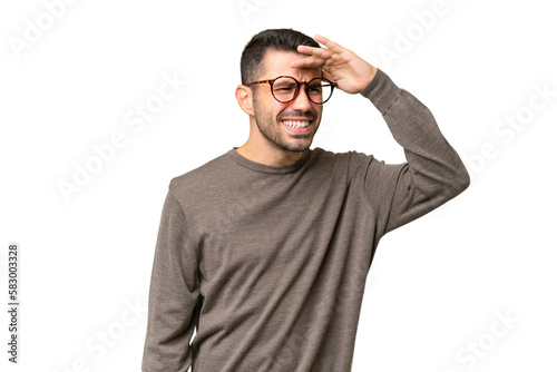 Young handsome caucasian man over isolated background looking far away with hand to look something