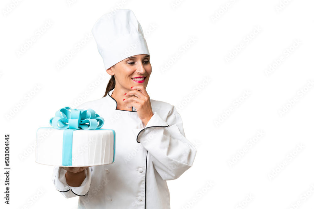 Middle-aged chef caucasian woman with a big cake over isolated background thinking an idea and looking side Middle-aged chef caucasian woman with a big cake over isolated background thinking an idea and looking side