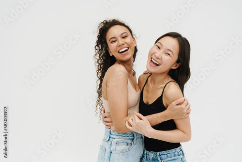 Two cheery girls hugging isolated over white background