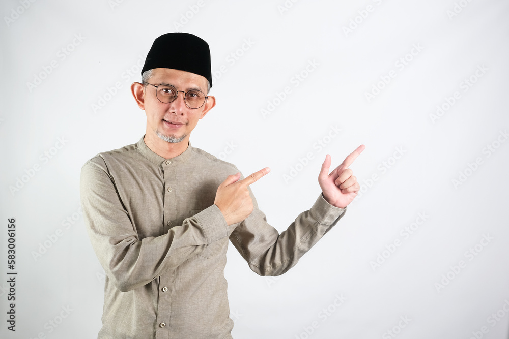 Portrait of Moslem Asian Man pointing hands and finger to the side. (explain something).
Portrait of Moslem Asian Man pointing hands and finger to the side. (explain something).