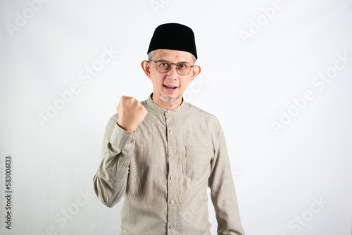 Portrait of Asian Moslem Man with a spirited expression ,celebrating success isolated over white background. 