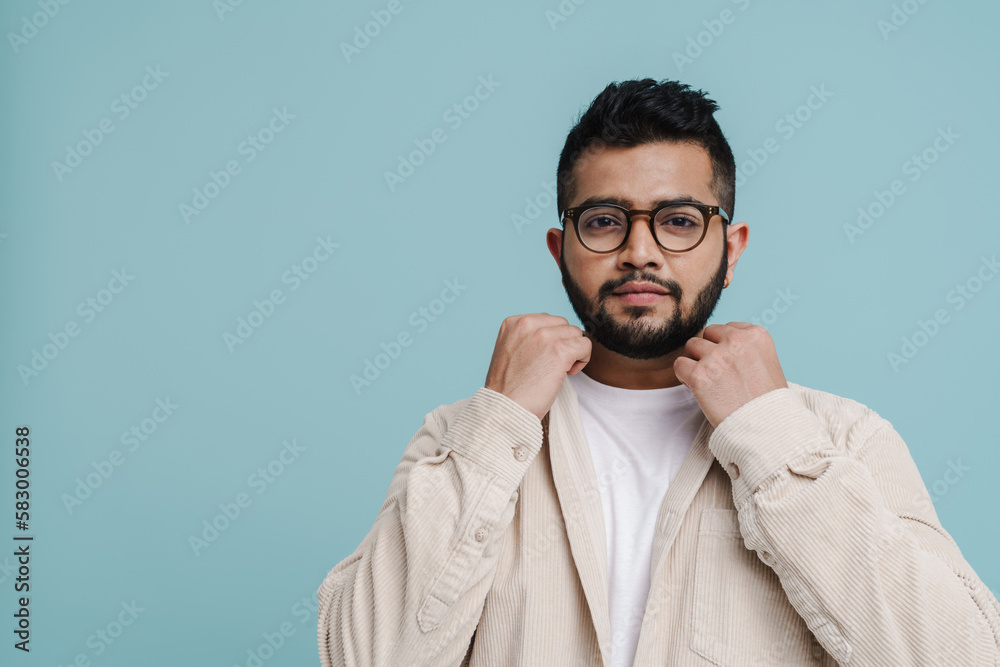 Young indian guy posing isolated over blue background Young indian guy posing isolated over blue background