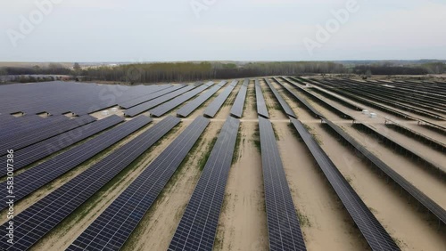 Solar panles producing green energy. Large solar farm in countryside. Drone jib shot photo