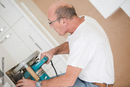 male carpenter applying wood stain
