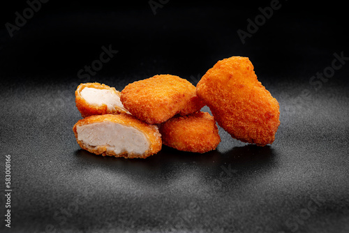 A pile of chicken nuggets isolated on black color background