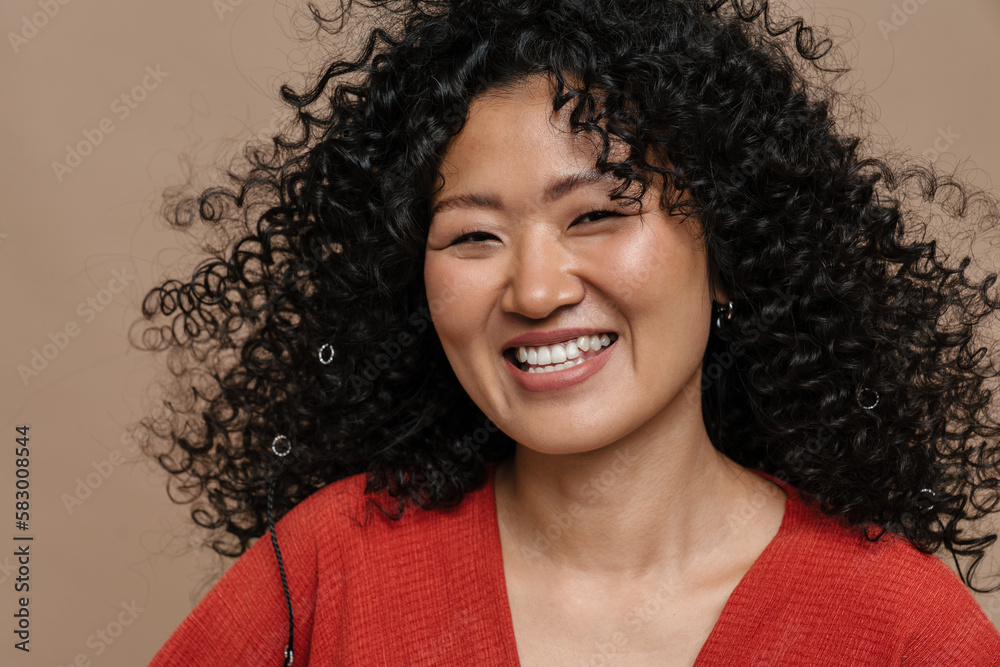 Asian woman smiling at camera isolated over beige background Asian woman smiling at camera isolated over beige background
