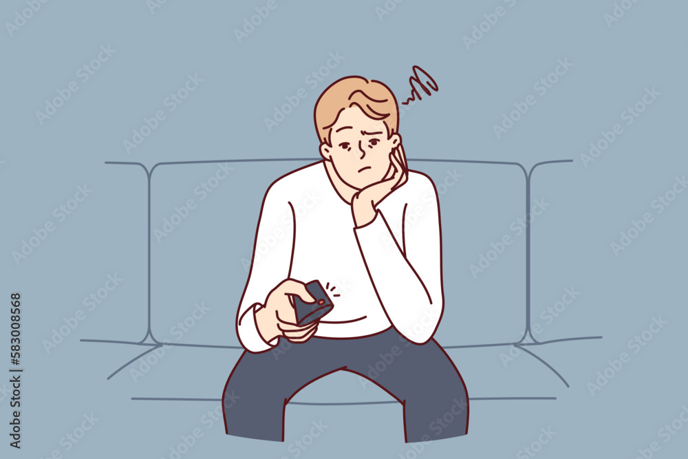 Bored man holding TV remote due to lack of satellite TV channels with interesting shows. Concept frustration and procrastination associated with lack of motivation caused by emotional burnout Bored man holding TV remote due to lack of satellite TV channels with interesting shows. Concept frustration and procrastination associated with lack of motivation caused by emotional burnout