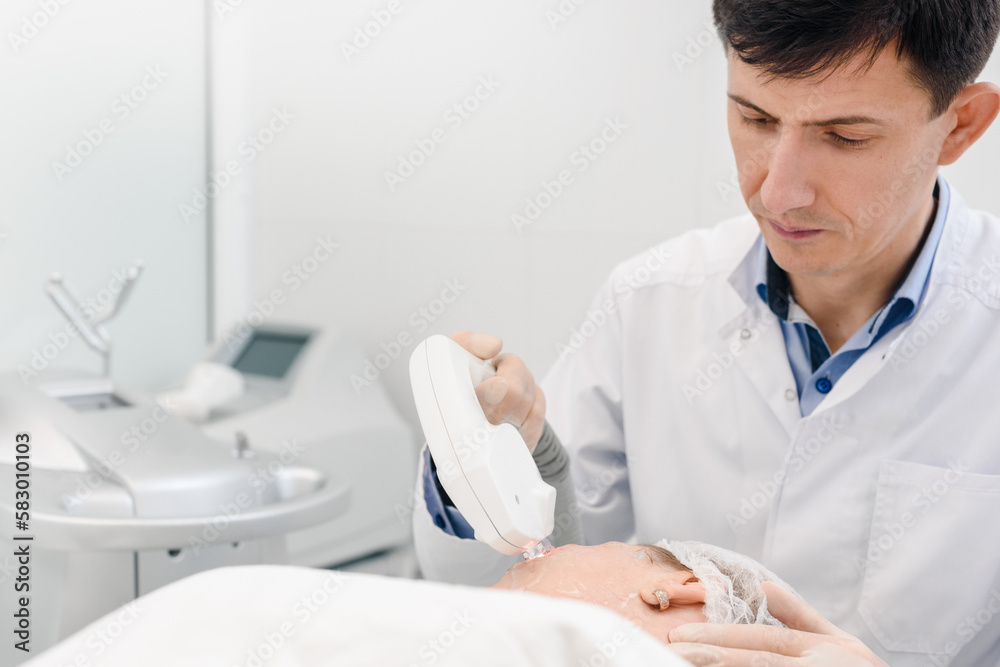 Concentrated male beautician doing anti-aging rejuvenation procedure for female client