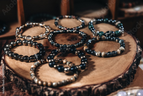 Bracelets dark stone beads on a natural wood stand