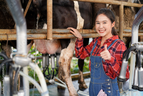 Professional Asian female animal husbandry working in dairy milk farm.