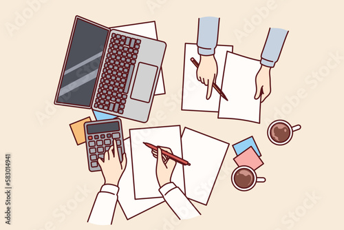 Hands of accountants doing financial accounting over table with payment documents and calculator, top view. Auditors calculate invoice or tax budget company and provide advisory services for business