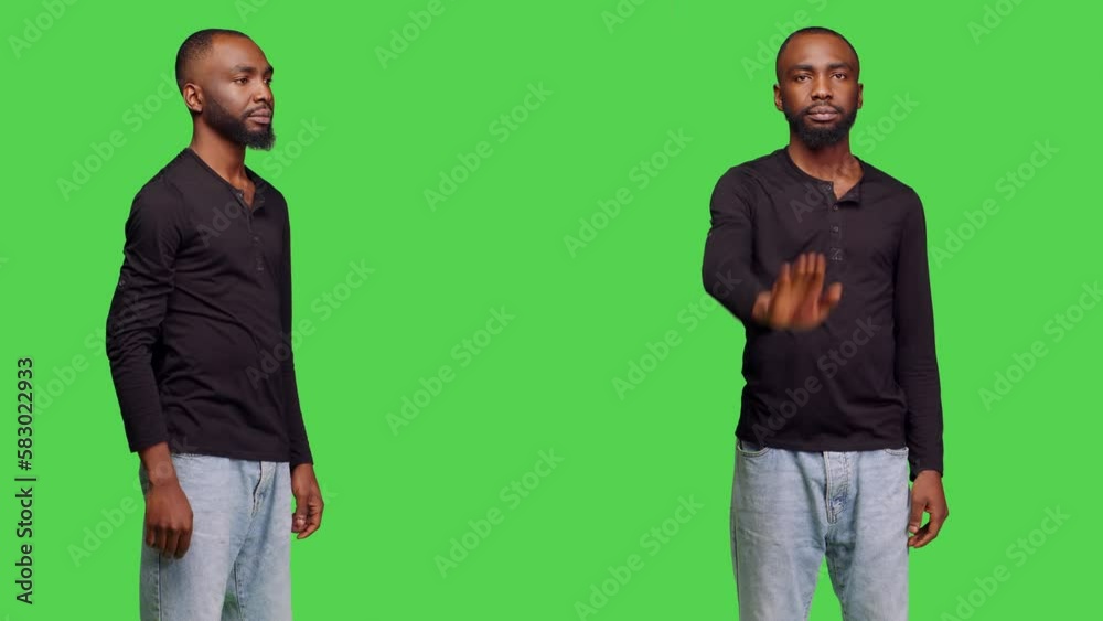 Negative adult showing no sign with palm on camera, expressing refusal and rejection over greenscreen in studio. Male model having negative reaction, doing disapproval gesture. Negative adult showing no sign with palm on camera, expressing refusal and rejection over greenscreen in studio. Male model having negative reaction, doing disapproval gesture.