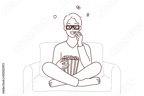 Smiling guy watching movie eating popcorn 