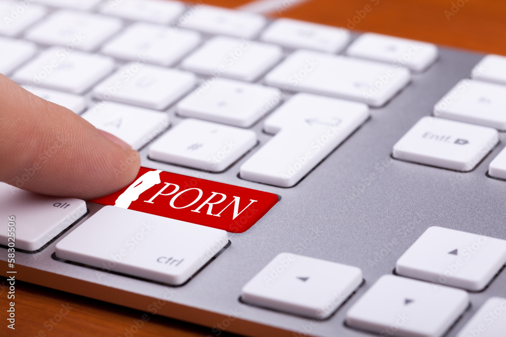 Finger pressing on red button with porn word and naked woman silhuette on it. Sex and xxx sites. Adult content only
