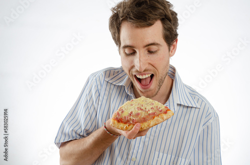 A man smiles as he looks at a piece of pizza. Isolated white background for text space