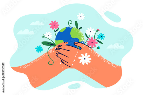 Two hands with planet earth and flowers symbolize environmental activism and care for nature