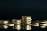 Close up of money coin stack on black background with selective focus. Business and financial background.