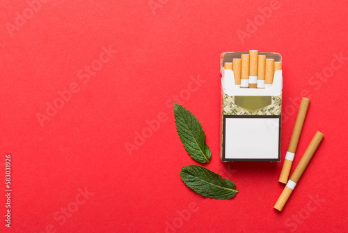 Pack of menthol cigarettes and fresh mint on colored table, Menthol cigarettes top view flat lay