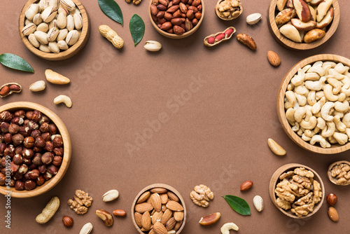 mixed nuts in wooden bowl. Mix of various nuts on colored background. pistachios, cashews, walnuts, hazelnuts, peanuts and brazil nuts