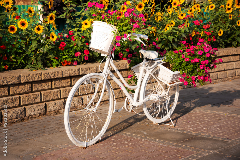 White bicycle with flowers in a garden