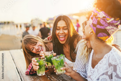 Canvas Print Multiracial happy friends cheering and drinking mojitos at beach party - Focus o