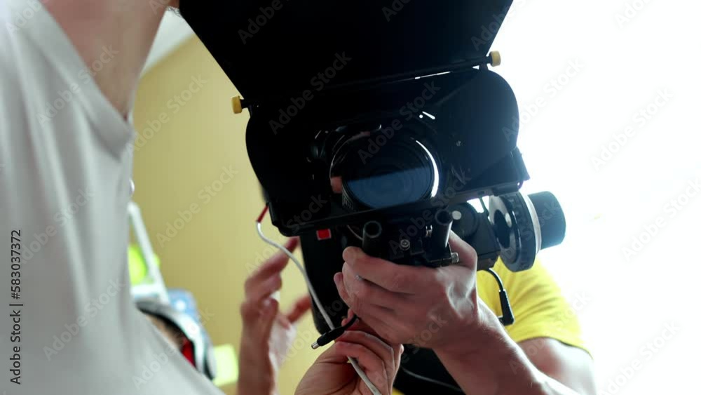 Cameraman operator holds cinema camera in hands, lens with matte box