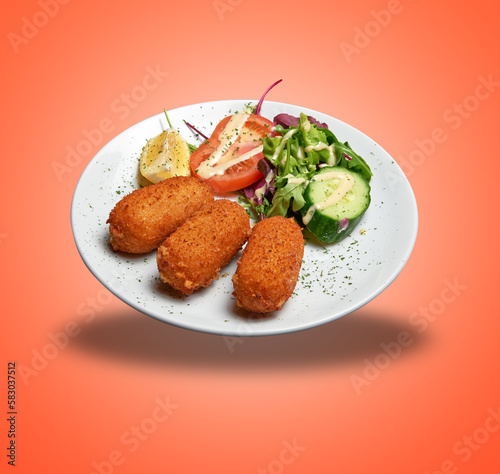 Floating White plate with three Shrimps croquettes ans salad