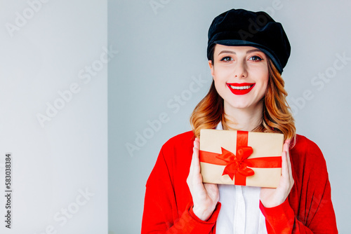 woman in red cardigan and hat with gift box photo