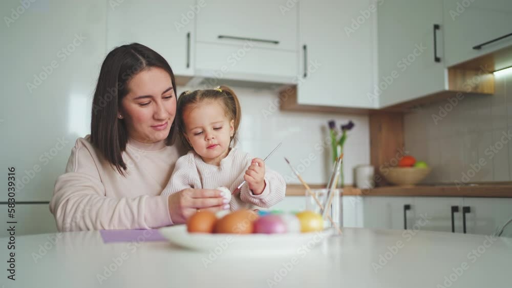 Happy Easter Holiday. Beautiful mother and daughter paint and decorate an egg Happy Easter Holiday. Beautiful mother and daughter paint and decorate an egg