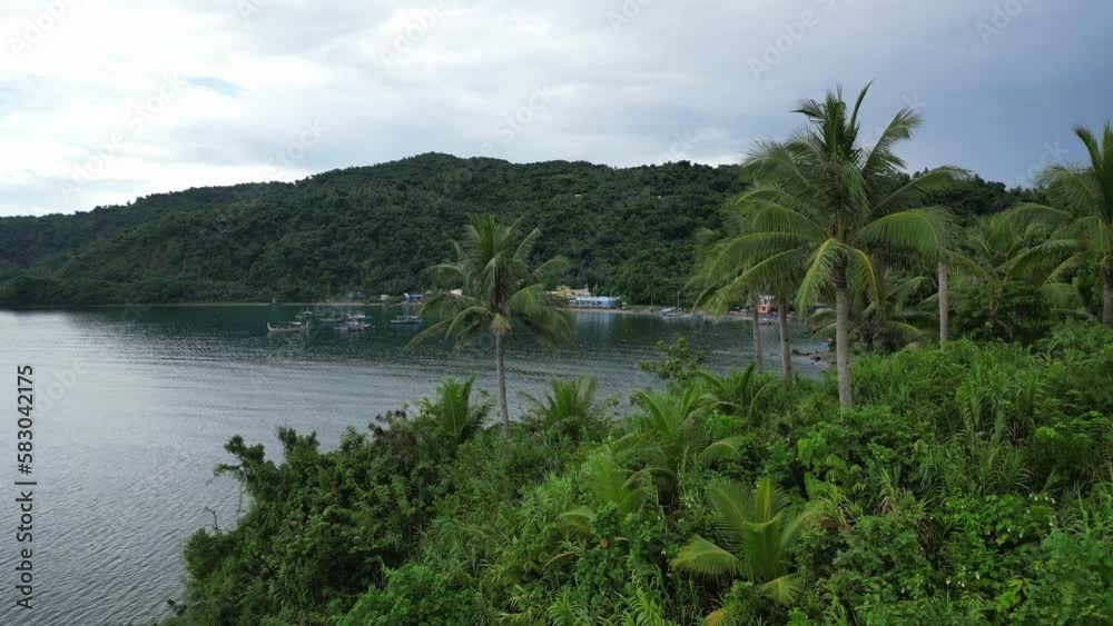 Rising, Establishing Aerial View of Philippine Tropical Island, revealing rural fishing community and lush jungles along tranquil ocean waters. Rising, Establishing Aerial View of Philippine Tropical Island, revealing rural fishing community and lush jungles along tranquil ocean waters.