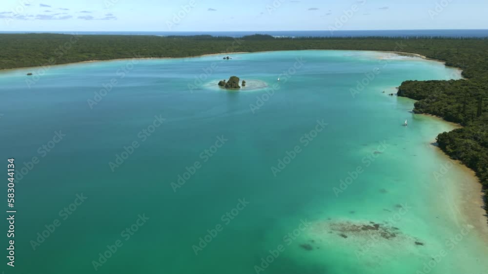 Traditional pirogues on pristine waters of Upi Bay, Isle of Pines in New Caledonia - pull back aerial reveal Traditional pirogues on pristine waters of Upi Bay, Isle of Pines in New Caledonia - pull back aerial reveal
