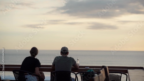 Silhouette of a couple watching a beautiful sunset on the coast of a tropical island © asokova