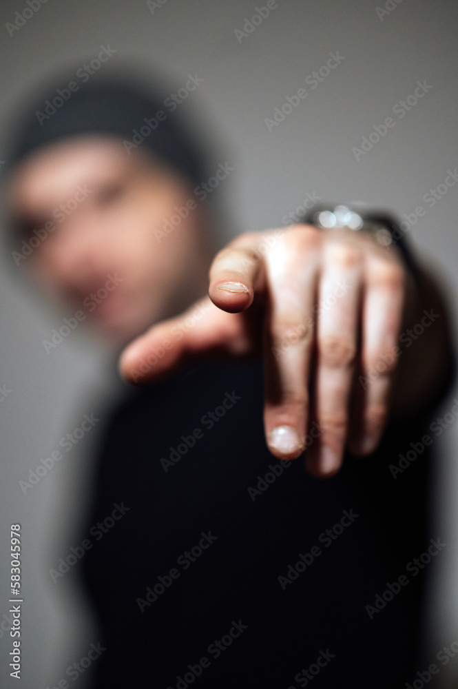 Serious dramatic man looking away while standing against black studio background