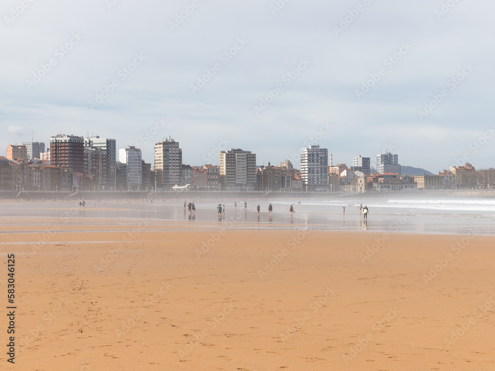 Beautiful landscape of San Lorenzo Beach in Gijón, Asturias, Spain. People walking on the beach at the weekend. Beautiful landscape of San Lorenzo Beach in Gijón, Asturias, Spain. People walking on the beach at the weekend.