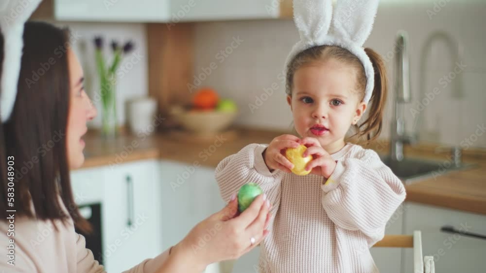 Happy Easter. Beautiful mother and daughter are knocking painted eggs Happy Easter. Beautiful mother and daughter are knocking painted eggs