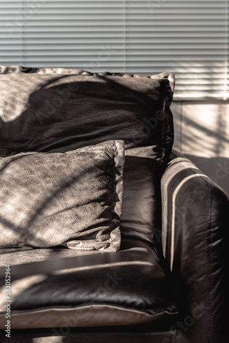 Close up of black feather sofa with sun shines on it.