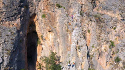 Huge eroded mountains rock on a summer day. Woman alpinist on the cliff. People and adventures concept.