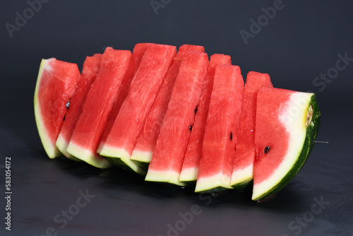 Cut pieces of red ripe delicious juicy watermelon on a black background