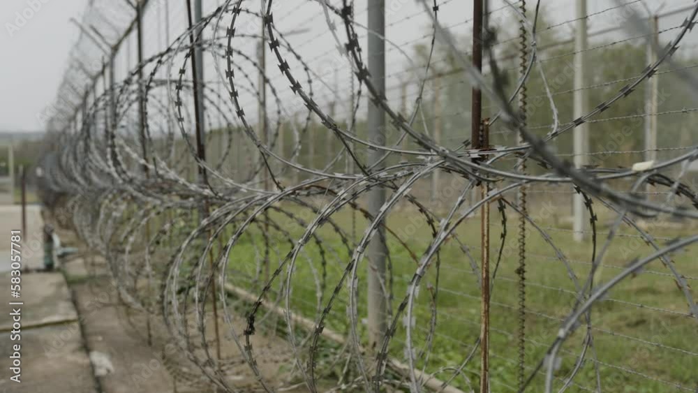 High Security Razor Wire Fence inside a Prison, Barbed Wire Metal Fence along the Border Protection, Smooth CInematic Shot High Security Razor Wire Fence inside a Prison, Barbed Wire Metal Fence along the Border Protection, Smooth CInematic Shot